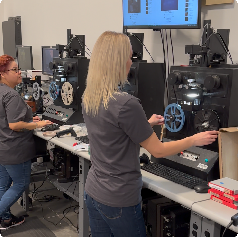A modern family watching old home movies on a laptop, laughing together.